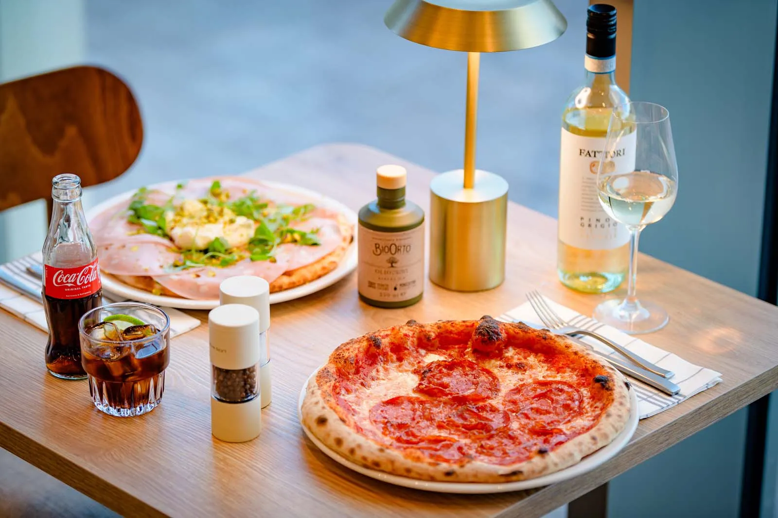 Pizza with salami, wine and a pizza with ham